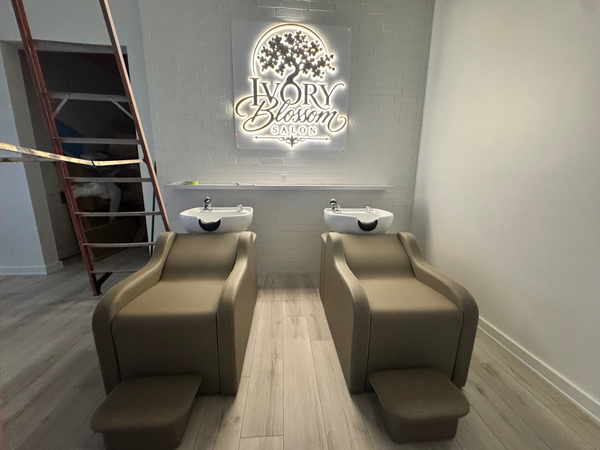 Two reclining shampoo chairs beneath the illuminated Ivory Blossom Salon sign