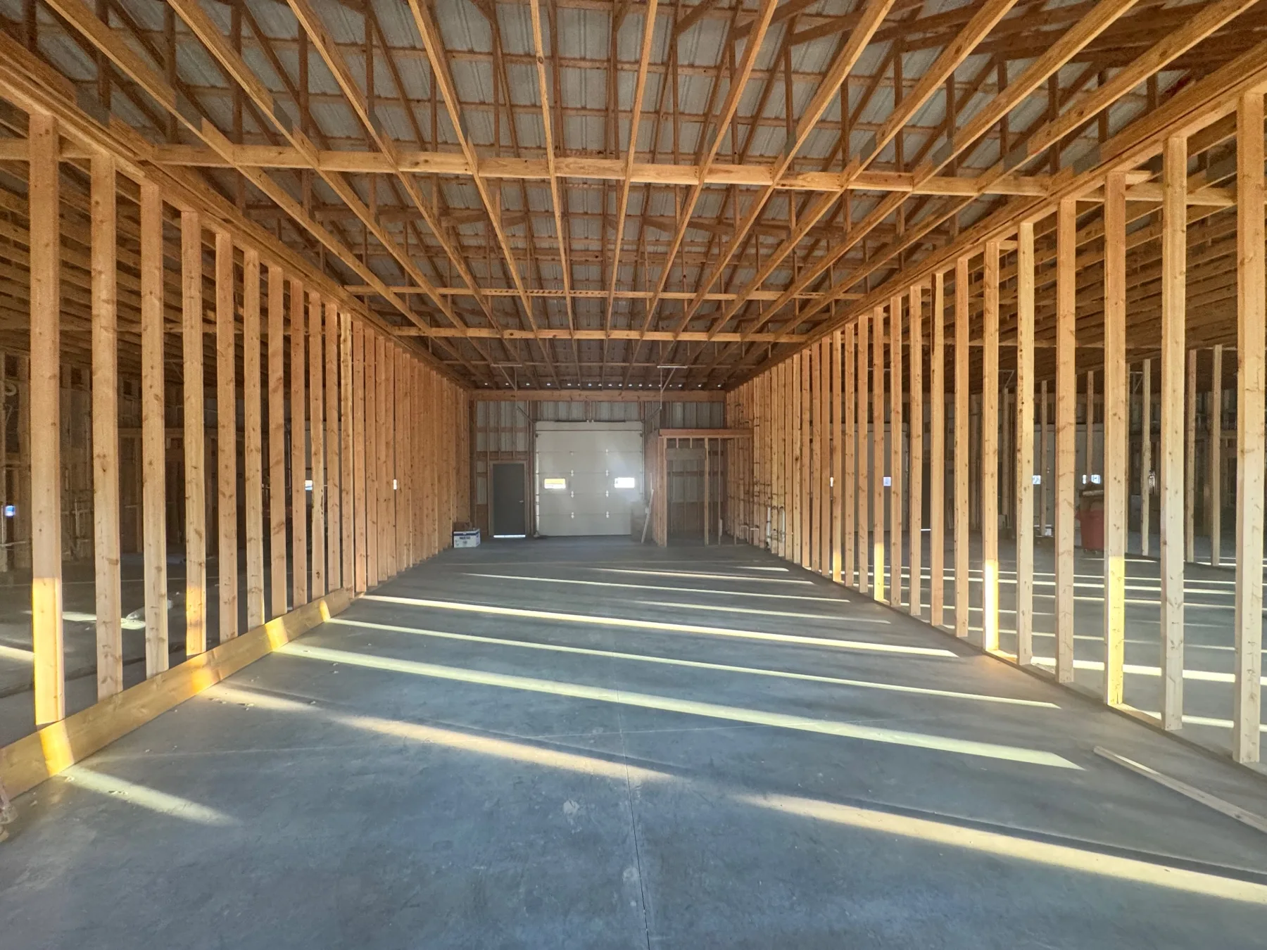Interior stud framing and open ceiling structure inside the Ivory Blossom Salon build