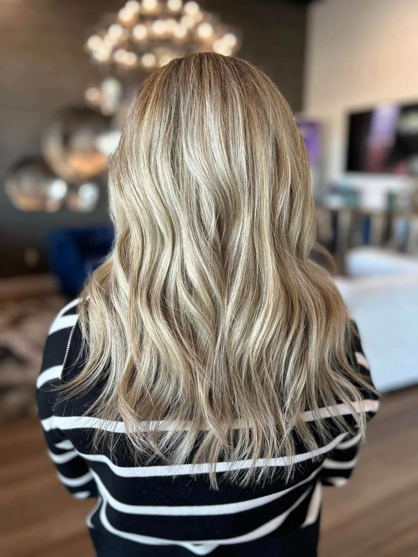 Long dimensional blonde hair with soft waves, photographed from behind